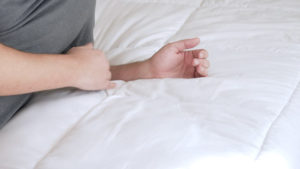 A man rests on his arm using the Utopia Down Alternative comforter